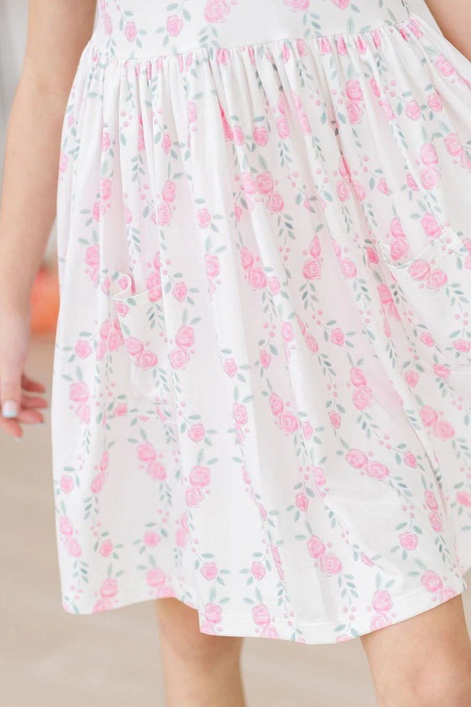 mila & rose short sleeve soft twirly dress with pockets in rosie posie print.  white background with pink roses